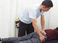 寝ている患者の骨盤を調整するようす