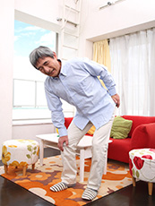 膝を押さえて痛がる白髪男性